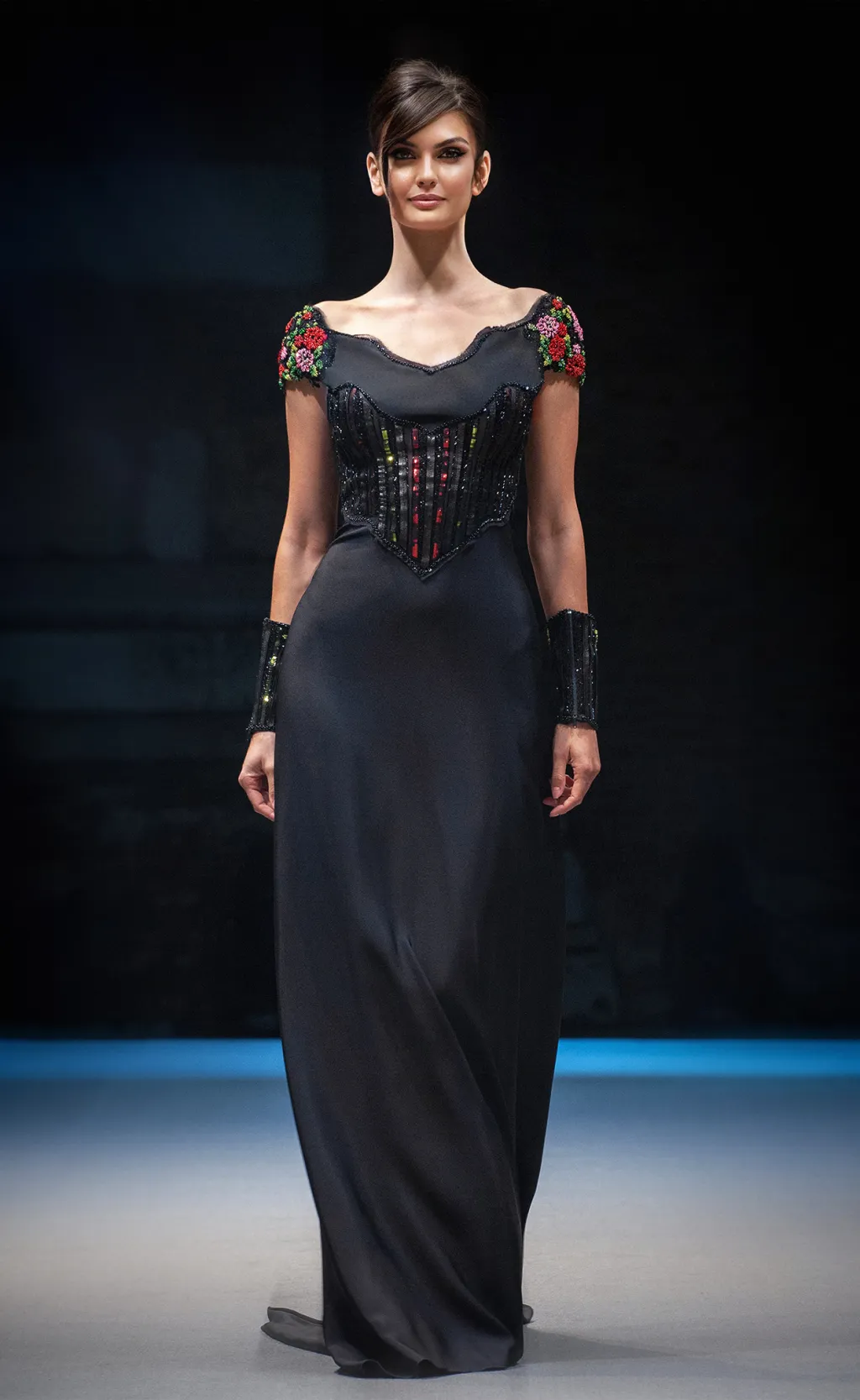 Black gown with embroidered corset and floral sleeves on the runway