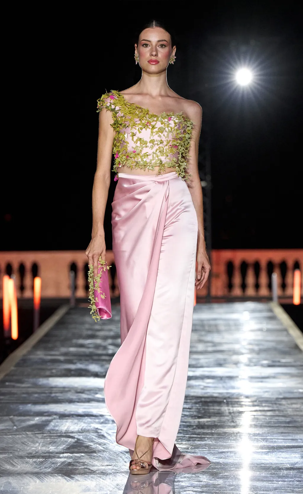 Pink satin skirt with a one-shoulder top of green leaves on the runway